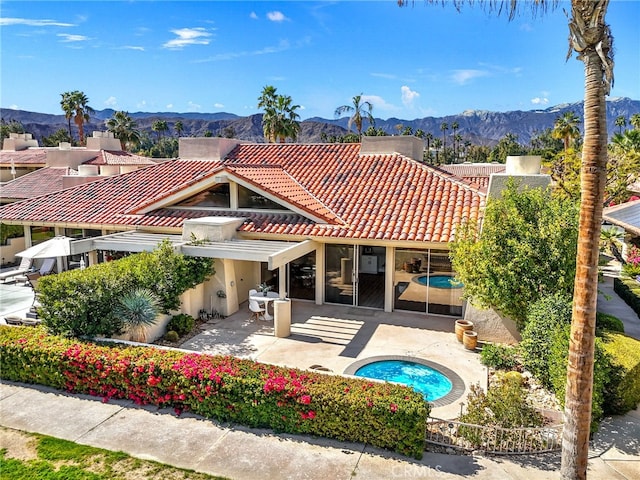 back of property with stucco siding, a patio, a tiled roof, and a mountain view