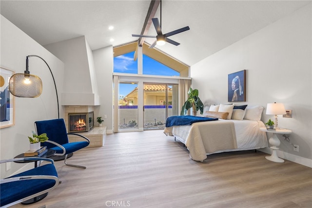 232 Kavenish Dr W, Rancho Mirage, CA 92270 - bedroom with wood finished floors, access to exterior, beamed ceiling, a glass covered fireplace, and high vaulted ceiling