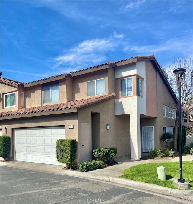 townhome / multi-family property with a garage and stucco siding