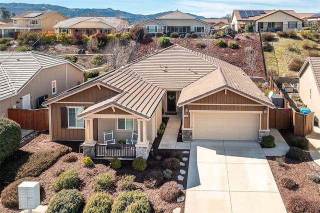 view of front facade with a mountain view, a garage, a tile roof, concrete driveway, and a residential view