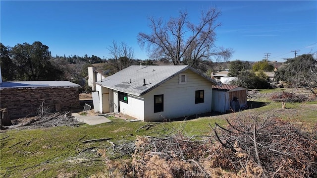 back of house with a chimney and a yard