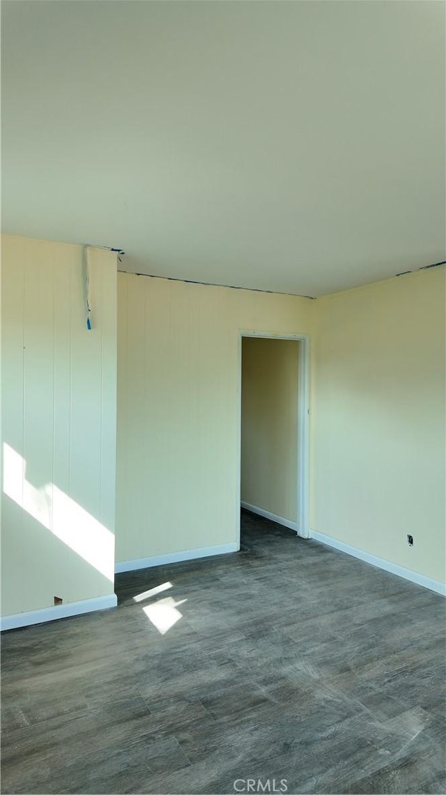 unfurnished room with baseboards