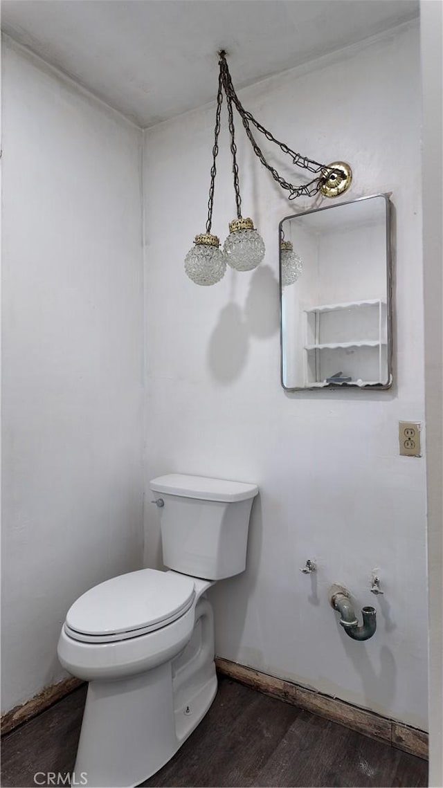 bathroom with toilet, baseboards, and wood finished floors