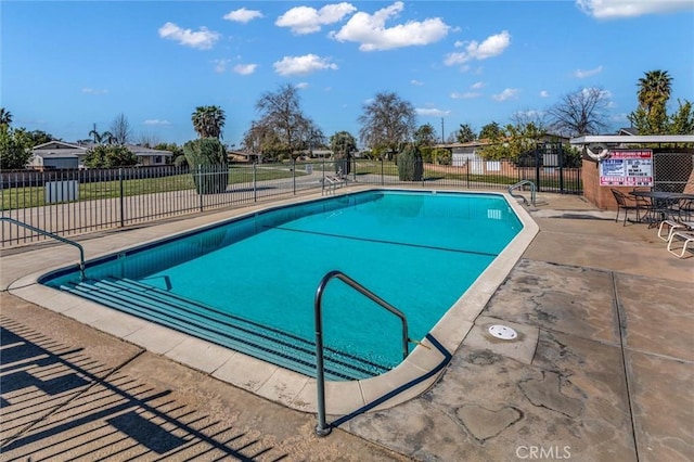 community pool with fence and a patio