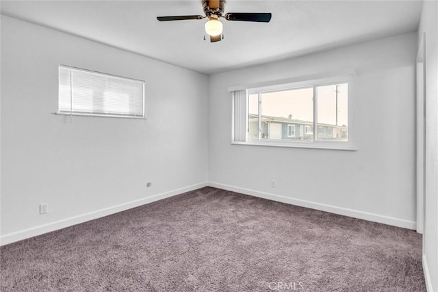 carpeted spare room with baseboards and a ceiling fan