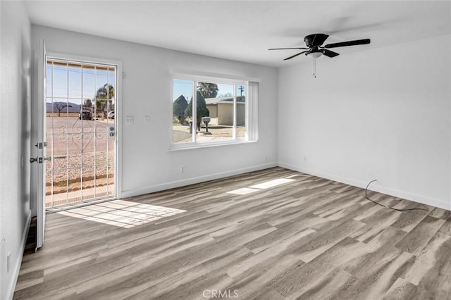 unfurnished room featuring light wood-style flooring, baseboards, and ceiling fan