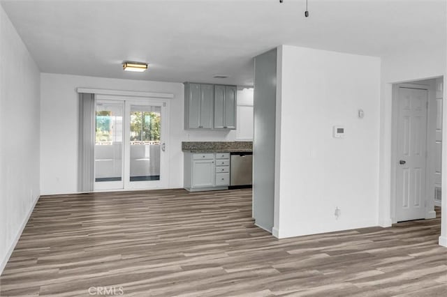 kitchen featuring dishwasher, wood finished floors, and gray cabinetry