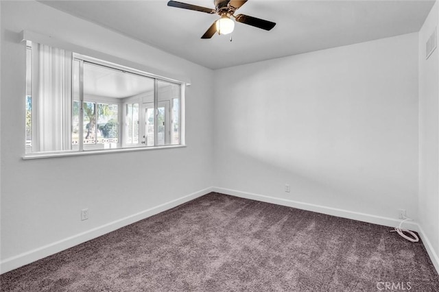 empty room featuring a ceiling fan, carpet, visible vents, and baseboards