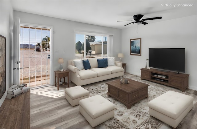 living room with a ceiling fan and light wood finished floors