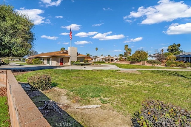 view of community featuring a lawn and fence