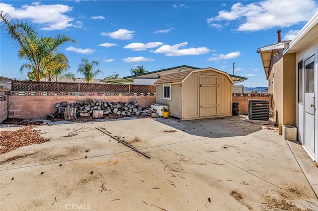 view of patio / terrace featuring a storage shed, central AC, an outbuilding, and a fenced backyard