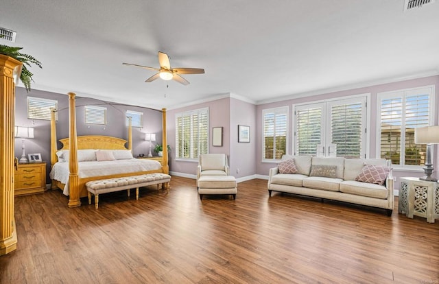 bedroom featuring ornamental molding, wood finished floors, and baseboards