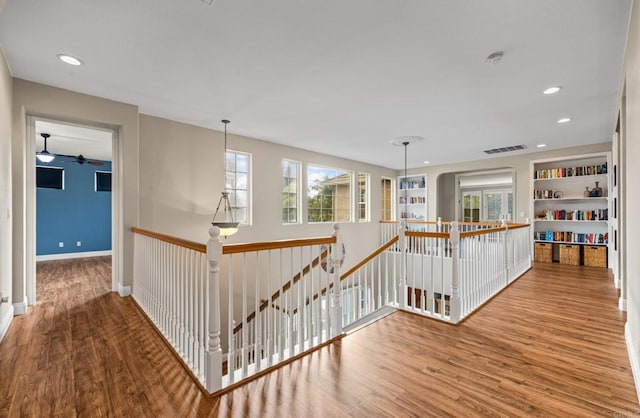 hall featuring visible vents, wood finished floors, an upstairs landing, and recessed lighting