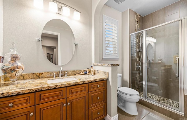 full bathroom with toilet, a shower stall, and vanity