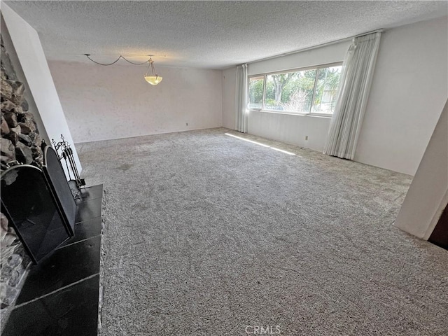 unfurnished living room with a textured ceiling and dark colored carpet