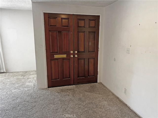 interior space featuring a textured ceiling and carpet floors