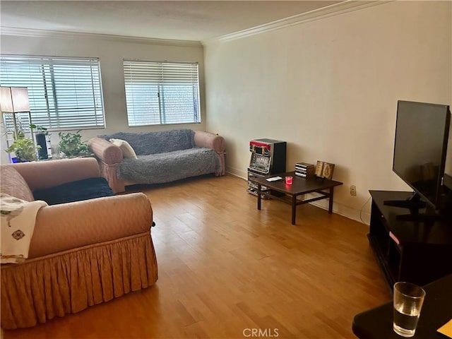 living room with ornamental molding, light wood-type flooring, and baseboards