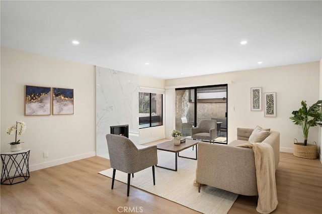 living room featuring baseboards, light wood-type flooring, and recessed lighting