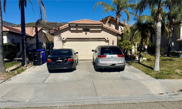 view of front of house with a garage, driveway, a tile roof, a residential view, and stucco siding