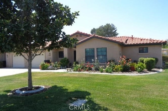 view of front of house with concrete driveway, a front yard, a tiled roof, and stucco siding