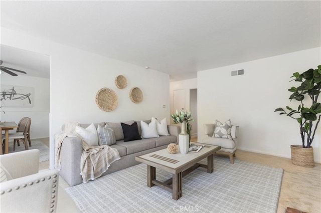 carpeted living room featuring a ceiling fan and visible vents