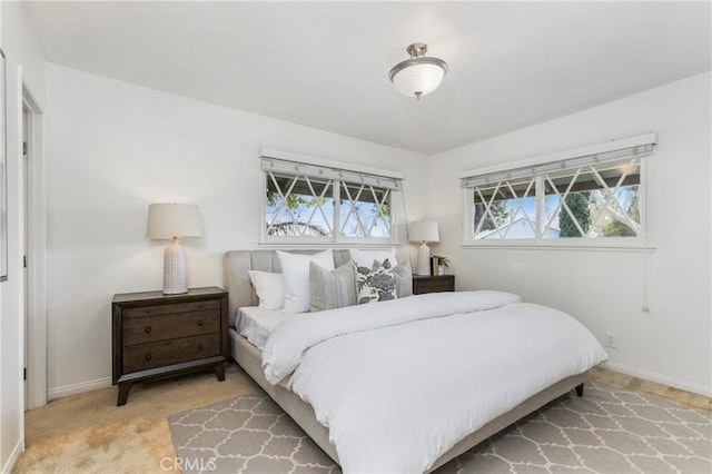 bedroom featuring carpet floors, multiple windows, and baseboards