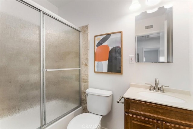 bathroom with visible vents, vanity, toilet, and combined bath / shower with glass door