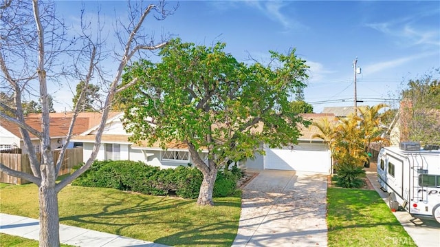 view of property hidden behind natural elements featuring a garage, a front yard, driveway, and stucco siding