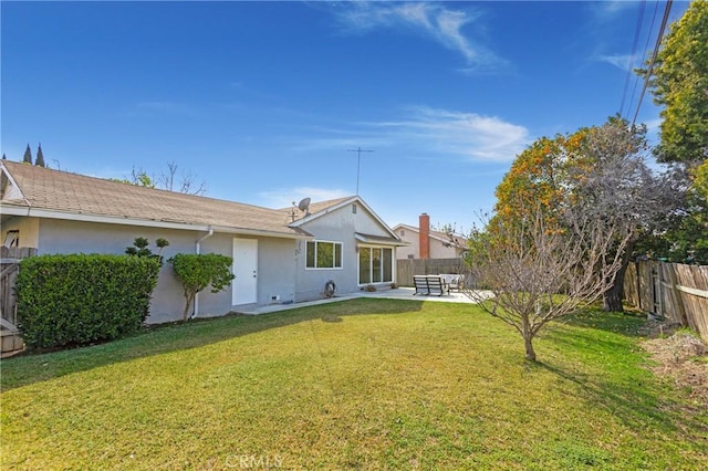 rear view of property with a yard, a patio, a fenced backyard, and stucco siding