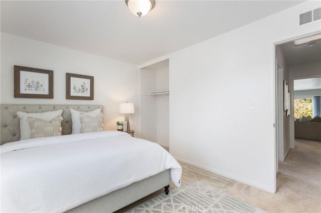 bedroom with light colored carpet, a closet, visible vents, and baseboards