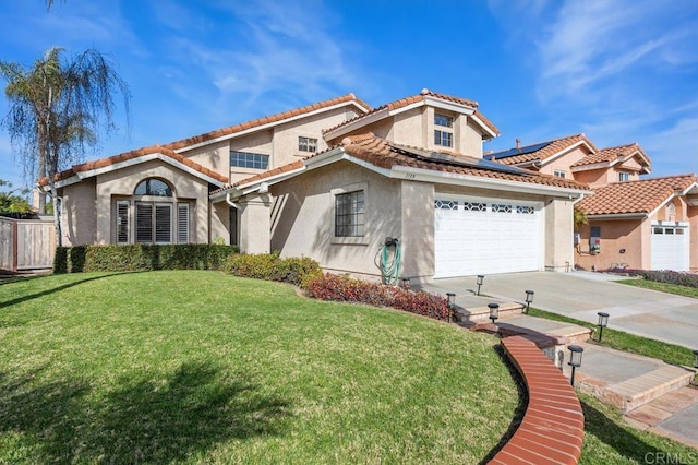 mediterranean / spanish house with an attached garage, a front lawn, concrete driveway, and stucco siding