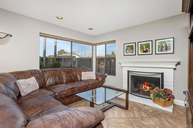 living area with light tile patterned floors, baseboards, a tile fireplace, and recessed lighting