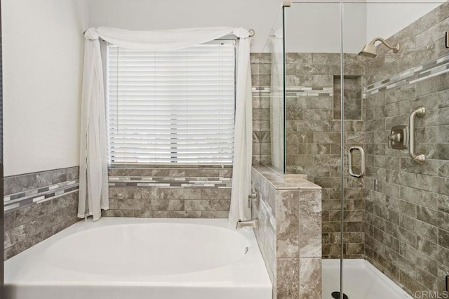 bathroom with a garden tub and a shower stall