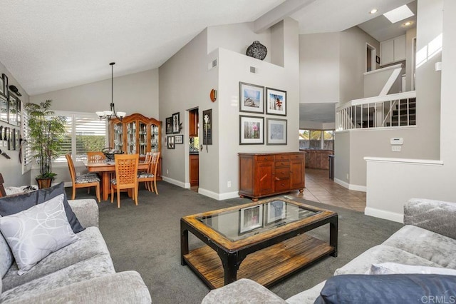 carpeted living room with high vaulted ceiling, visible vents, baseboards, beamed ceiling, and an inviting chandelier