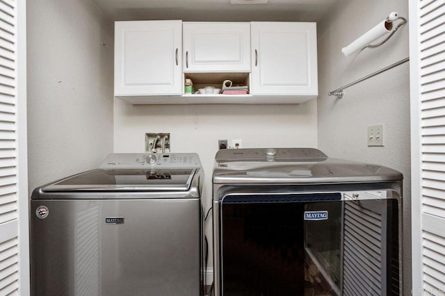 laundry area featuring visible vents, washer and clothes dryer, and cabinet space