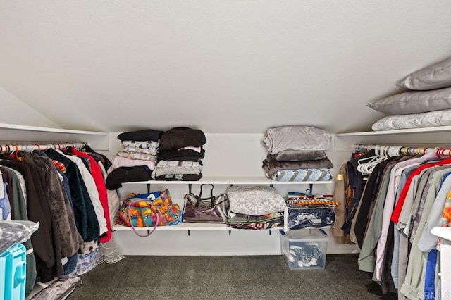 spacious closet with vaulted ceiling and dark carpet