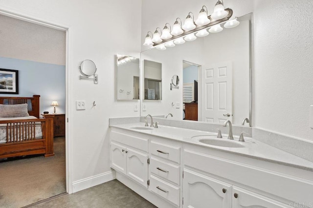 bathroom featuring a sink, double vanity, connected bathroom, and baseboards