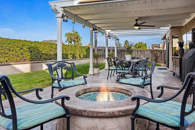 view of patio featuring a fire pit, outdoor dining area, a fenced backyard, and a ceiling fan