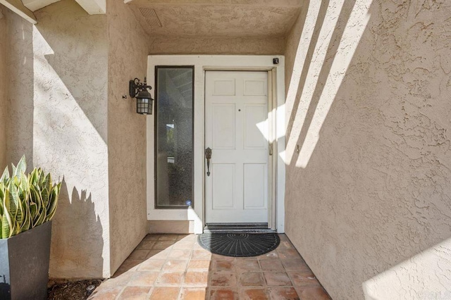 doorway to property featuring stucco siding