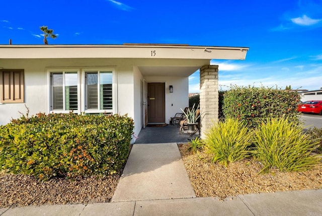 view of exterior entry featuring stucco siding