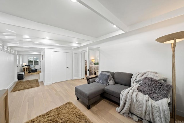 living room with light wood-type flooring and beam ceiling