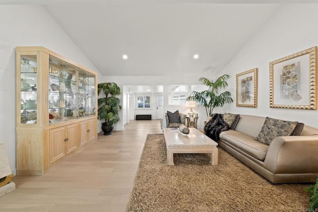 living area with lofted ceiling, light wood finished floors, and recessed lighting