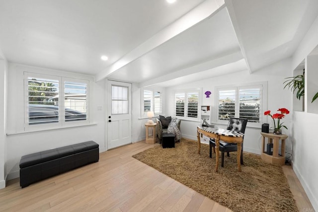 interior space with a healthy amount of sunlight, light wood finished floors, baseboards, and beamed ceiling