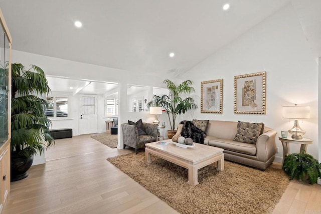 living room with recessed lighting, vaulted ceiling, and light wood-style flooring