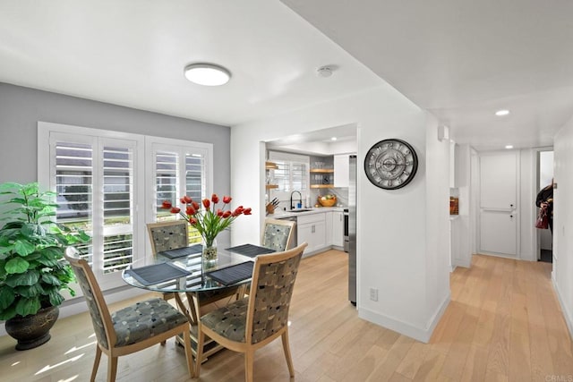 dining space featuring light wood-type flooring, baseboards, a wealth of natural light, and recessed lighting