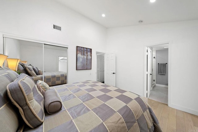 bedroom with high vaulted ceiling, recessed lighting, visible vents, and light wood finished floors