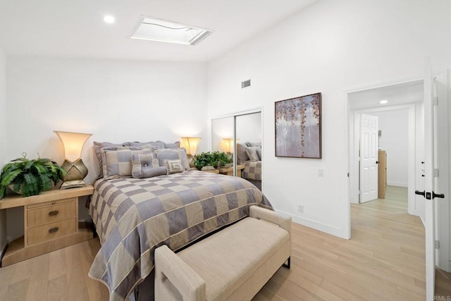 bedroom featuring a skylight, a closet, visible vents, and light wood-style flooring