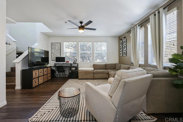 living area featuring dark wood-style flooring, ceiling fan, and stairway