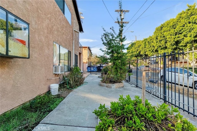 exterior space with cooling unit, fence, and stucco siding