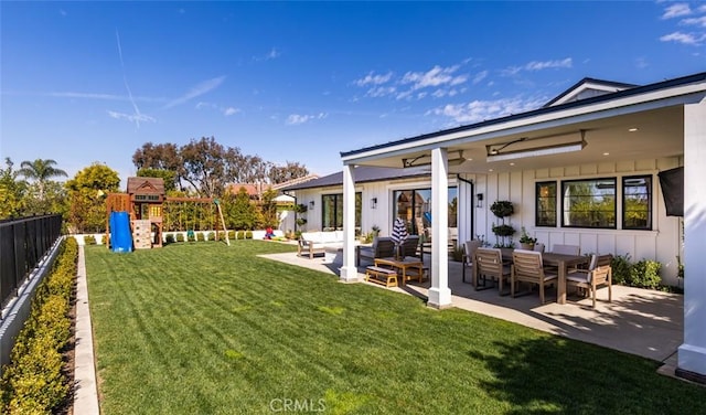 view of yard featuring outdoor lounge area, a playground, a patio, and a fenced backyard